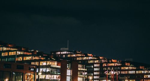 Low angle view of illuminated buildings against sky at night