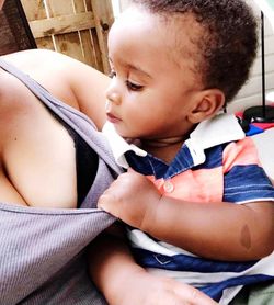 High angle view of baby boy sitting in bedroom