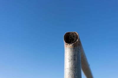 Low angle view of metal structure against blue sky