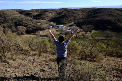 Rear view of boy standing on rock