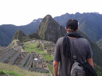 Rear view of male tourist  looking at machu picchu pichu mountains
