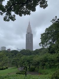 View of trees and buildings against cloudy sky