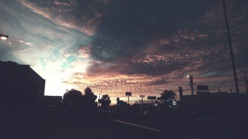 Silhouette city against sky during sunset