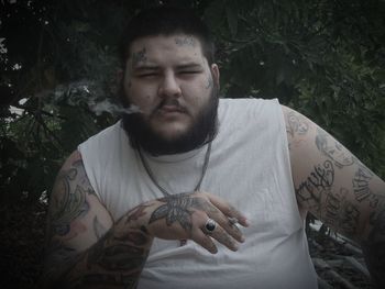 Portrait of young man holding camera outdoors