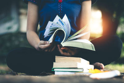 Low section of person sitting on book