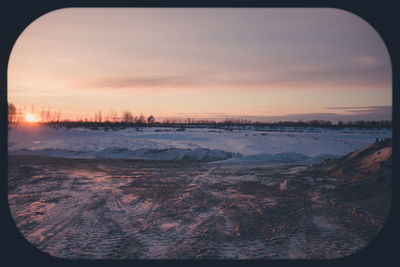 Scenic view of frozen lake against sky during sunset