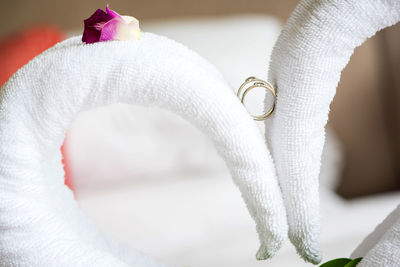 Close-up of wedding rings on towels in bedroom