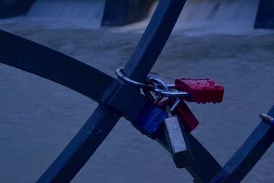 Wet locks attached on railing against river during rainy season