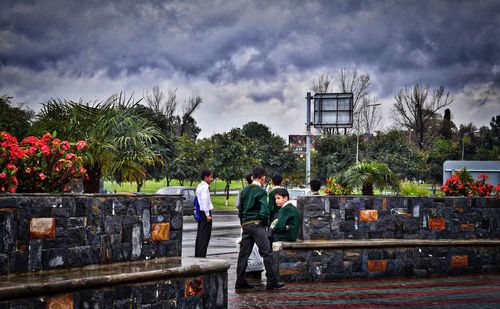 Person standing on road against cloudy sky