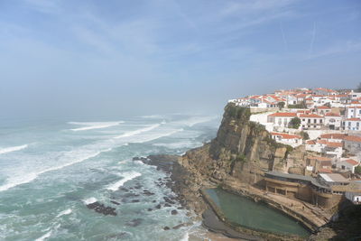 Aerial view of sea and buildings against sky