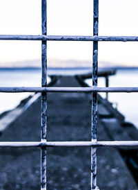 Close-up of metal fence against sky