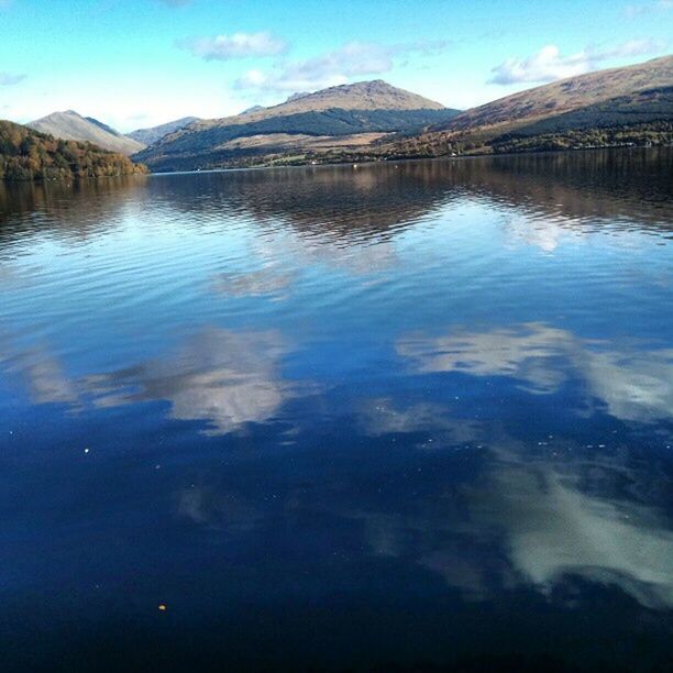 water, reflection, lake, mountain, tranquility, tranquil scene, scenics, beauty in nature, waterfront, sky, blue, nature, standing water, mountain range, idyllic, calm, outdoors, no people, day, rippled