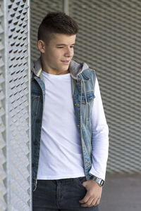 Thoughtful teenage boy standing outdoors