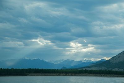 Scenic view of lake and mountains against cloudy sky