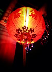 Low angle view of illuminated lanterns hanging at night