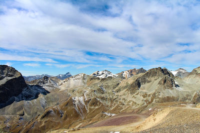 Scenic view of mountain range against cloudy sky