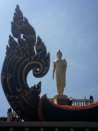 Low angle view of statue against building against clear sky