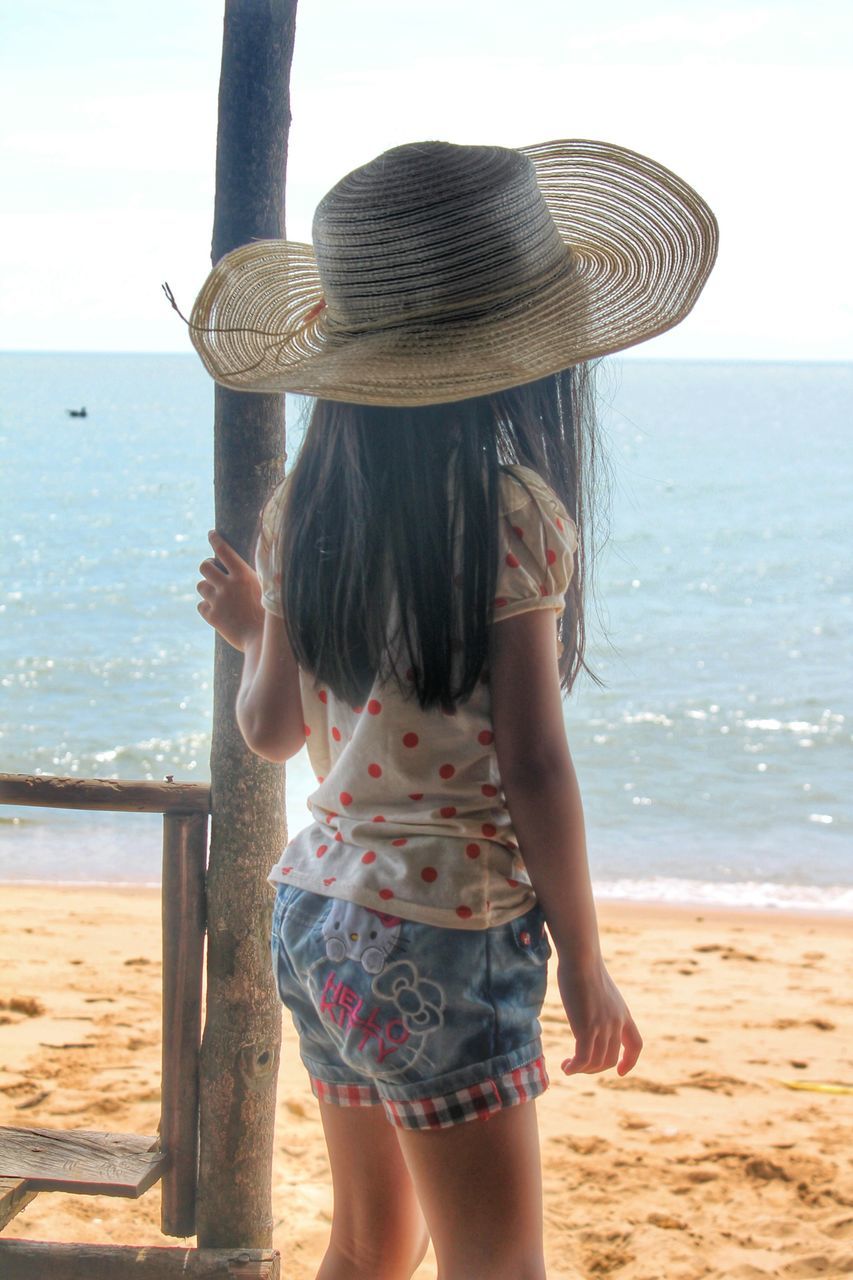 sea, beach, water, leisure activity, horizon over water, lifestyles, shore, sky, rear view, standing, vacations, person, long hair, young adult, sand, young women, casual clothing