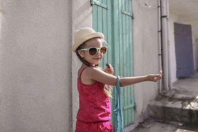 Portrait of girl standing by wall