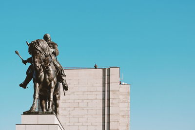 Low angle view of statue against clear blue sky