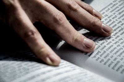 Cropped image of hands holding book