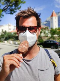 Portrait of young man holding ice cream cone