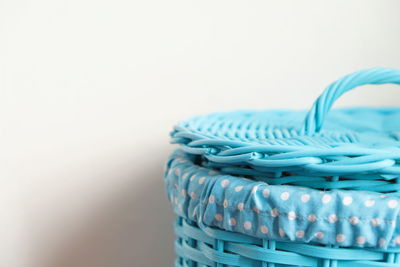 Close-up of wicker basket on table against white background