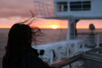 Woman silhouette on the ferry from riga to stockholm cruise ship at sunset over the baltic sea