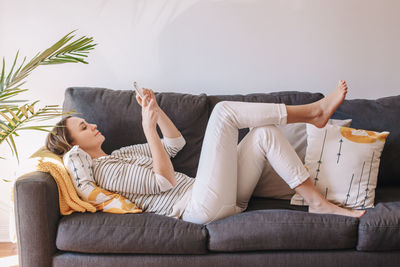 Woman sitting on sofa at home