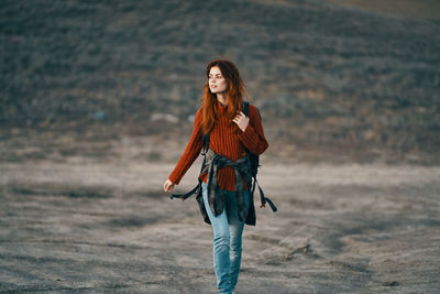 Woman with umbrella walking on land