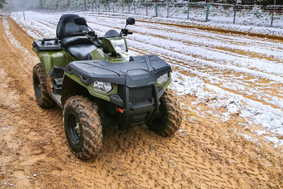 Atv stands on winter background on the state border. quad bike in the sand. 