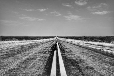 Railroad tracks on field against sky