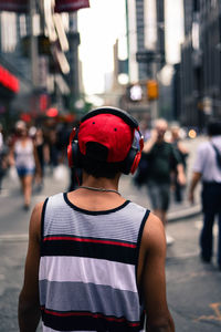 Rear view of a man with headphones on road