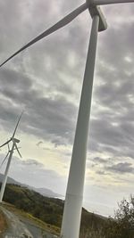 Wind turbine against cloudy sky