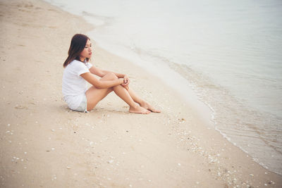 Young woman sitting at beach