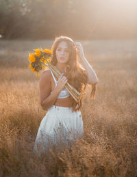 Portrait of smiling woman standing on field