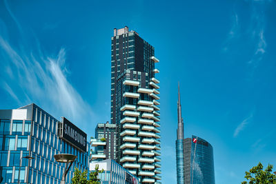 Low angle view of modern buildings against blue sky