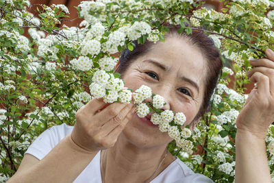 Portrait of woman standing by flowering plant