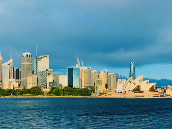 Buildings by city against sky