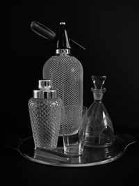 Close-up of glass bottle on table against black background