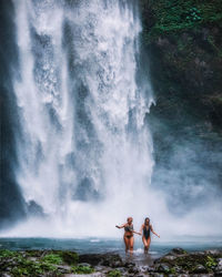 People enjoying in water splashing rocks