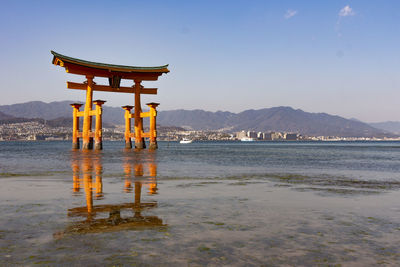 Lifeguard hut on beach by buildings against sky
