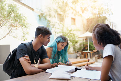 Friends studying while sitting at cafe