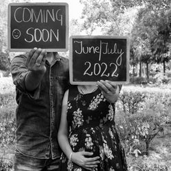 Indian couple posing for maternity baby shoot. the couple is posing in a lawn with green grass