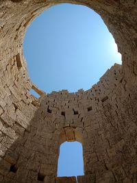 Low angle view of blue sky seen through hole