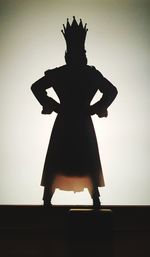 Silhouette woman standing against wall