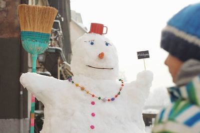 Boy making snowman in yard