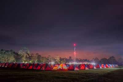 Crowd on field against sky at night