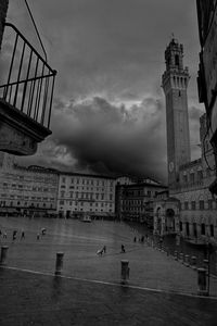High angle view of palazzo pubblico and torre del mangia against storm clouds