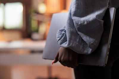 Midsection of woman holding book